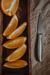 Orange in wooden background with metal knife