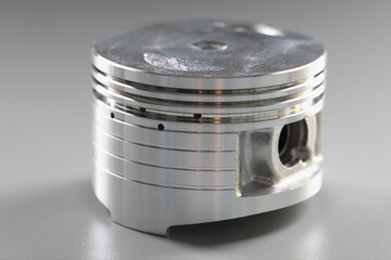 Metal brand new part for internal combustion engine laying on grey background