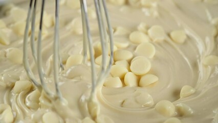 Process melt white chocolate. Tempering chocolate. Stir chocolate chips and liquid white chocolate. 4K UHD video
