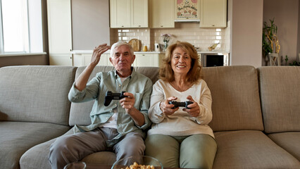 Dissatisfied man play video game with wife on sofa