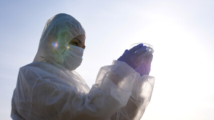 Scientist or ecology expert in protective costume with water samples probe for quality control from...