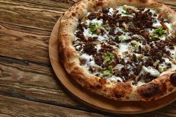 Delicious homemade pizza with mozzarella, mushrooms, beef and chicken. Wooden background, selective focus.