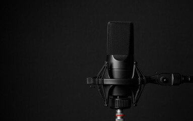 Professional microphone on black background. Podcast or recording studio