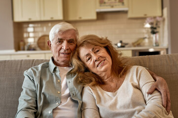 Senior caucasian couple sitting on sofa at home