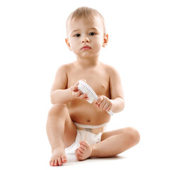 Little boy in diaper sitting and playing with brush.