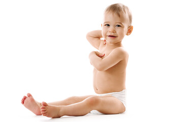 Curious healthy little boy in diaper sitting and smiling.