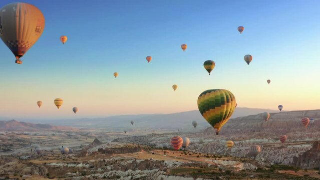 Aerial drone view of colorful hot air balloon flying over Cappadocia at summer sunrise. 4K.