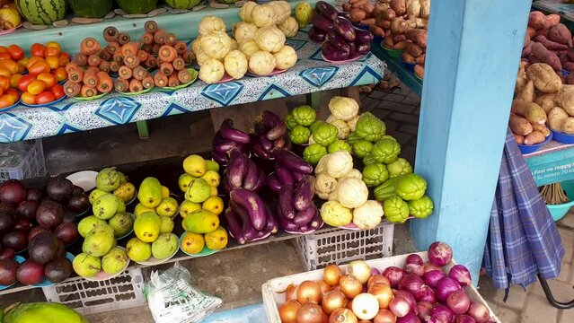 A mix of bright, colourful, healthy tropical fruit and vegetables including mangoes, aubergine and carrots neatly organised into bundles at a local produce market stall - Powered by Adobe