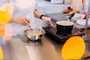 pastry chef to prepare custard dough. Pastry chef girl cooks custard on an induction cooker