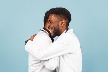 close-up portrait of a medical worker in a white lab coat with a stethoscope conferring with a young doctor on a blue background