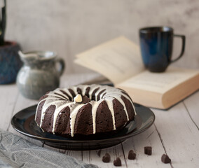 Dark chokolate bundt cake topped with white chokolate glaze and black currant