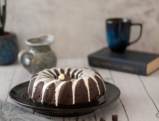 Dark chokolate bundt cake topped with white chokolate glaze and black currant