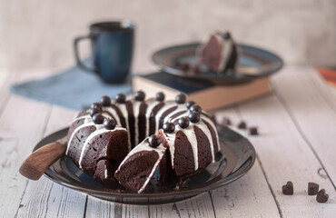 Dark chokolate bundt cake topped with white chokolate glaze and black currant