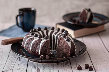 Dark chokolate bundt cake topped with white chokolate glaze and black currant