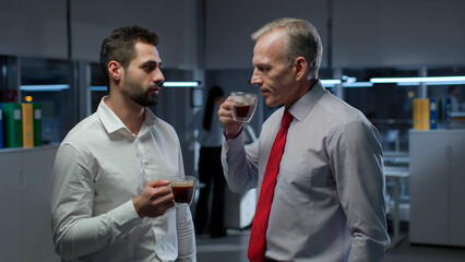 Business colleagues drink coffee and talk late in office