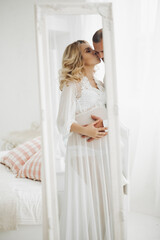 Naklejka premium Beautiful couple embracing stomach and touching face to face.