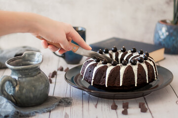 Dark chokolate bundt cake topped with white chokolate glaze and black currant