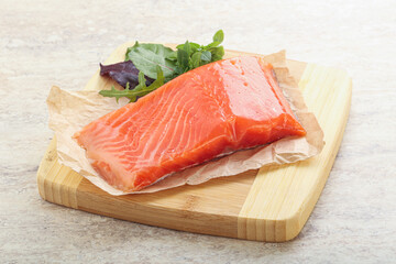 Raw salmon fillet over board
