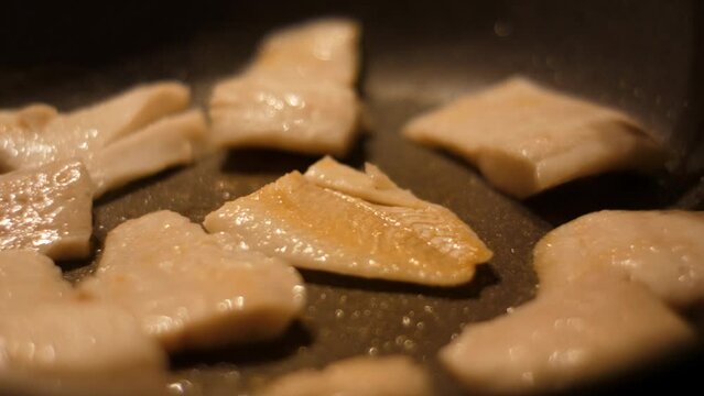Chef Flips Food Fish. Close up Frying Fillet Hake Fish of Frying Pan With Oil. Roast Healthy Food. Fried Cod Fish Pieces Fillet With Spice Closeup. Healthy Diet Food Omega 3. Low-calorie white meat.
