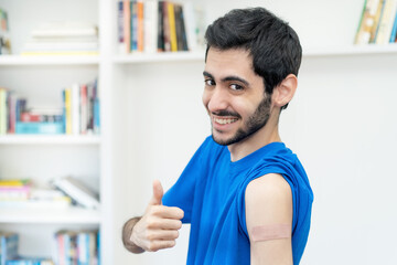 Arabic man showing thumb up after third vaccination against Covid 19