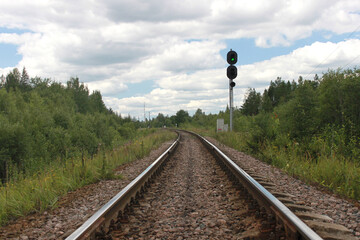 Railway traffic light shows green light.