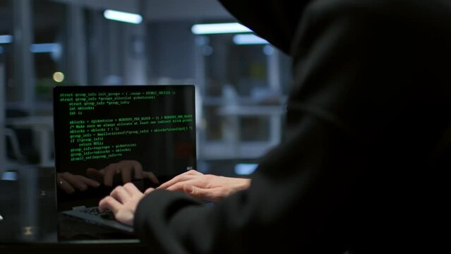 Computer hacker typing code on keyboard late night working and bypassing cyber security.