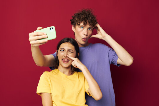 young man and girl in colorful T-shirts with a phone Youth style
