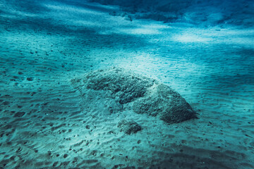 Underwater scene with rocks surrounded by sand