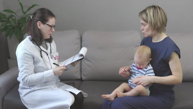 home doctor appointment, pediatrician visiting toddler baby child patient mother. female woman wearing medical uniform, glasses, stethoscope, holding clipboard, filling form, asking parent symptoms