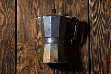 old aluminum teapot coffee maker. wooden background.