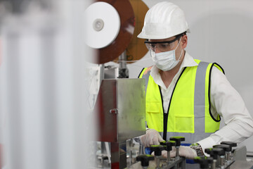 Caucasian mechanic technician maintenance, repairing industrial machinery equipment in factory. Professional worker in protective clothing with goggles and mask using wrench at manufacturing factory