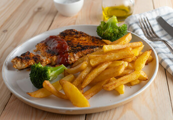 Grilled chicken breast with barbecue sauce and homemade french fries