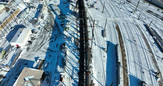 Railroad train tracks in railyard. Aerial in winter snow. Transportation shipping theme.