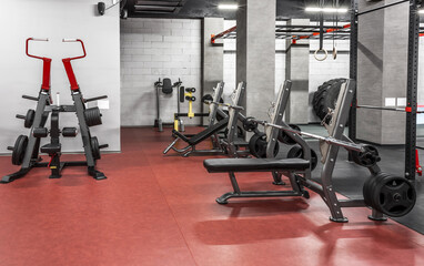 Fototapeta na wymiar Various powerlifting equipment in spacious, well lit, empty gym interior. Special modern exercise machines for physical training. Sport, fitness