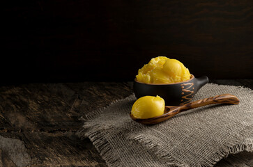 Pure or melted ghee. Diet concept with healthy fats. On a dark wooden table. Old rustic style.