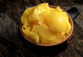 Pure or melted ghee. Diet concept with healthy fats. On a dark wooden table. Old rustic style.