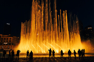 Dubai Dancing Fountain. Silhouettes of people enjoying the fountain show in Dubai at night, United Arab Emirates.