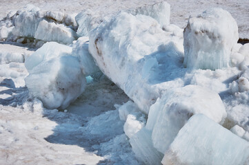 Melting ice floes in spring. A heap of blocks and fragments. Sunny day. Ice drift on the Amur River. Drifted ice pieces. Glare and shadows. © Алексей Игнатов