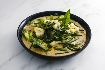 vegan green curry with broccoli cauliflower and green beans, healthy plant-based food