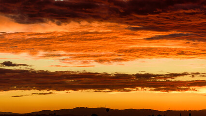 A moody orange sky over Melbourne, Australia, with the television towers on Mt Dandenong in the distance