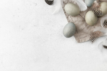 Eggs and feathers on a gray background. Easter celebration concept