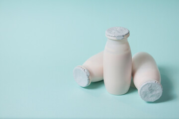 Bottles with probiotics and prebiotics dairy drink on light blue background.