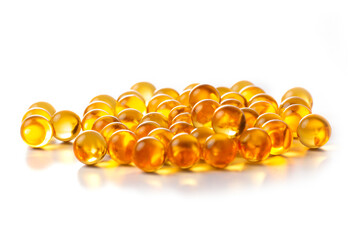 Round transparent yellow capsules with fish oil on a white background.