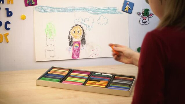 A girl draws a picture with colored bars