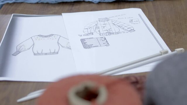 woman hands on working table, planning a sweater.
