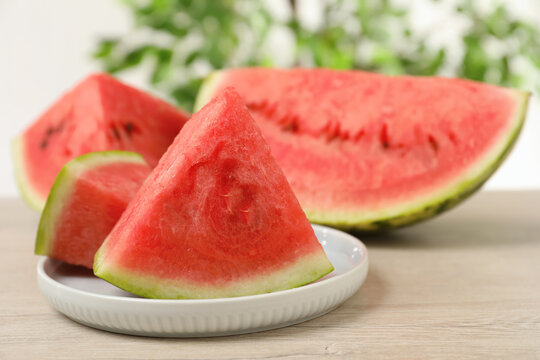 Slices of tasty ripe watermelon on light wooden table, closeup