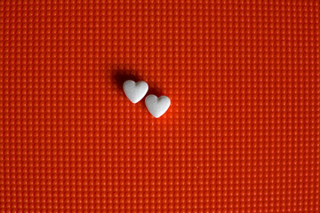 Two heart-shaped tablets lie on a textured surface.