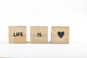 Wooden cubes with the inscription life is love on a white background