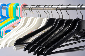 Metal rack with clothes hangers on grey background