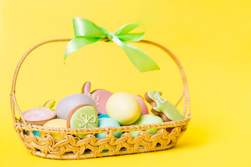Colorful easter cookies in basket with Multi colors Easter eggs on colored background . Pastel color Easter eggs. holiday concept with copy space